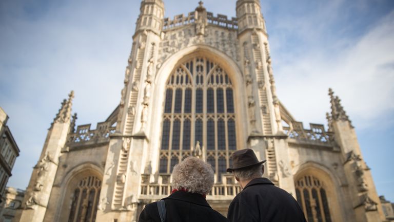 Visitors admire the west front of the Bath Abbey