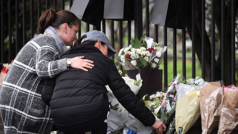People leave flowers at the scene