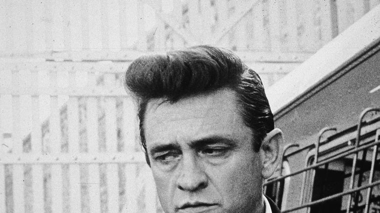 American country singer and songwriter Johnny Cash (1932 - 2003) walks inside the gates of Folsom Prison, preparing to perform his fourth concert for inmates there, California, 1964. (Photo by Hulton Archive/Getty Images)
