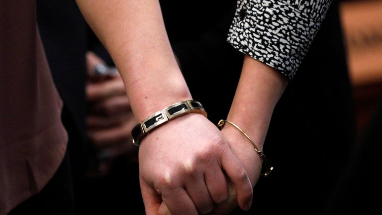 Victims and former gymnasts Maddie (L) and Kara Johnson hold hands as they speak at the sentencing hearing