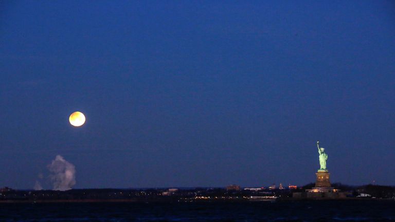 The &#39;Super Blue Blood Moon&#39; appears above the Statue of Liberty