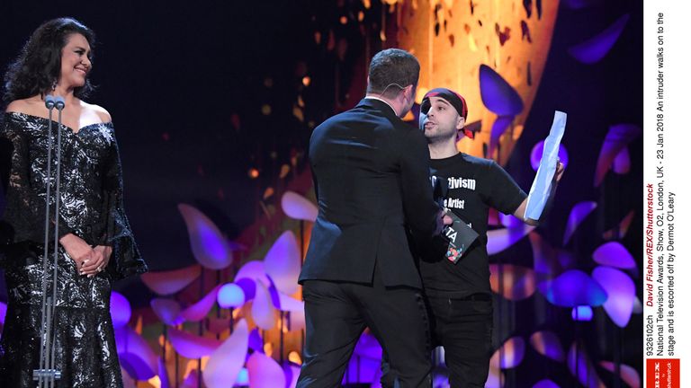 An intruder walks on to the stage and is escorted off by Dermot O&#39;Leary