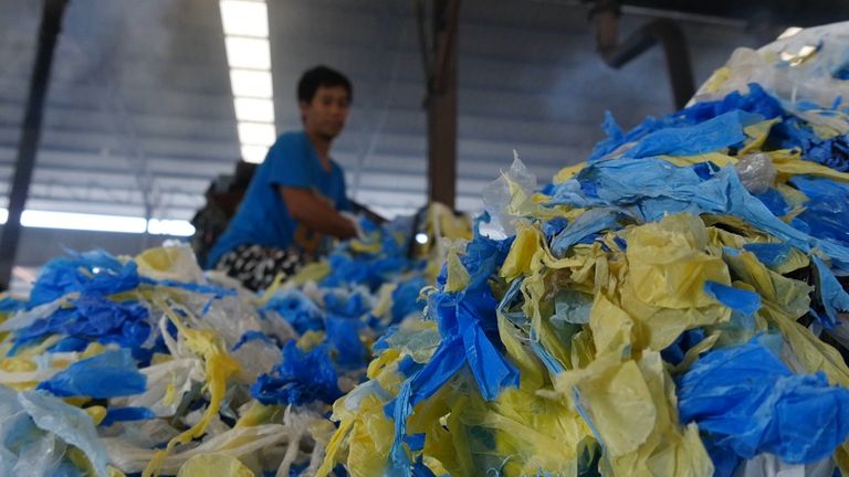 A worker in Thailand processes plastics recycling 