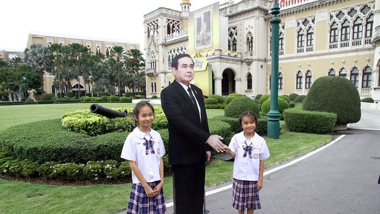Children pose next to a cardboard cut-out of Thailand&#39;s Prime Minster Prayuth Chan-ocha