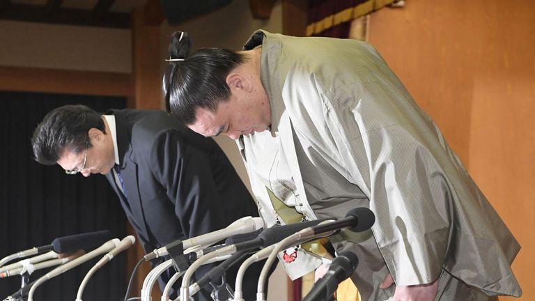 Harumafuji bows in apology with his stable master during his retirement conference. Pic: Kyodo/via REUTERS