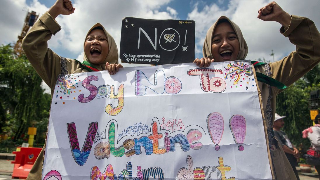 TOPSHOT - Girls from a local boarding school shout during an anti-Valentine&#39;s Day rally in Surabaya, East Java province on February 13, 2017. Conservative Indonesian Islamic groups have denounced Valentine&#39;s Day, saying it is un-Islamic, promoting promiscuity, casual sex and consumption of alcohol while other groups described the day as foreign cultural influence. About 90 percent of Indonesia&#39;s 255 million inhabitants are Muslim but most practise a moderate form of Islam and have lived largely 