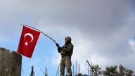 A Turkish soldier waves a flag on Mount Barsaya, northeast of Afrin, Syria January 28, 2018
