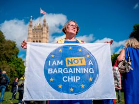 Demonstrators hold banners during a protest to Lobby MPs to guarantee the rights of EU citizens living in the UK, after Brexit, outside the Houses of Parliament in central London on September 13, 2017. After navigating the first hurdle of a key Brexit bill, British Prime Minister Theresa May on Tuesday won another parliamentary vote which will help prevent opposition MPs from blocking future legislation
