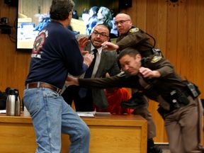 Randall Margraves (2ndL) lunges at Larry Nassar, (wearing orange)