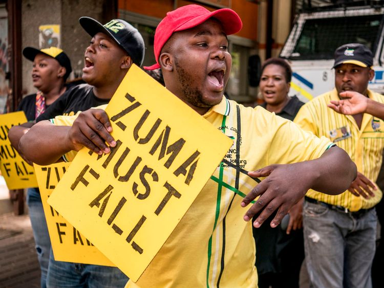 Supporters of the ANC Deputy President Cyril Ramaphosa hold placards and chant slogans outside the ANC party headquarter in Johannesburg