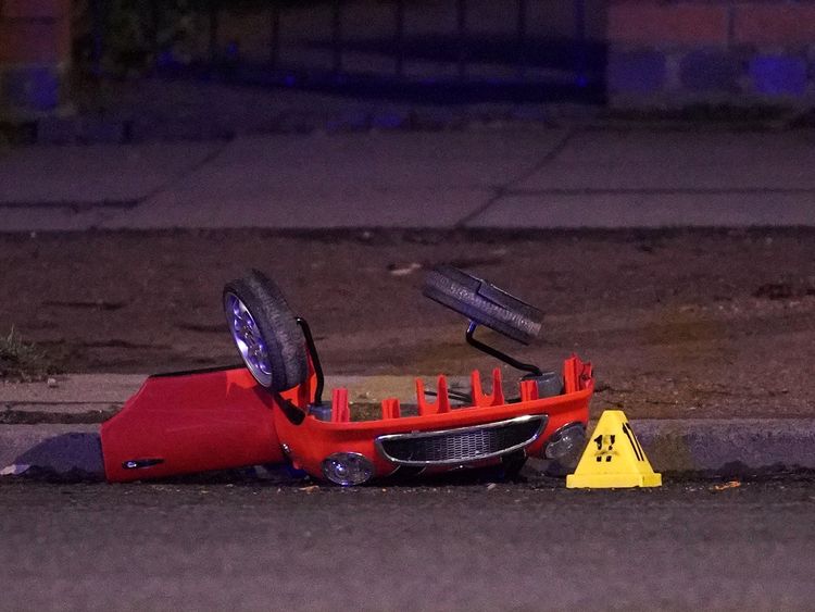 The remains of a toy car is marked by police accident markers  