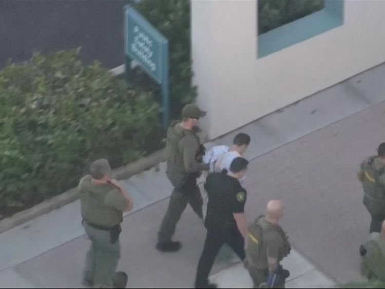 The suspect in the Florida school shooting is led into hospital
