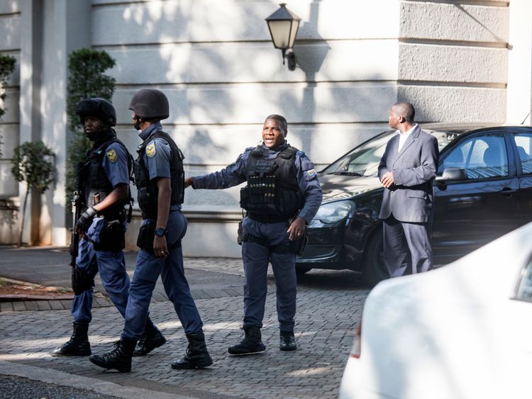 An armed South African Police member outside the Gupta residence