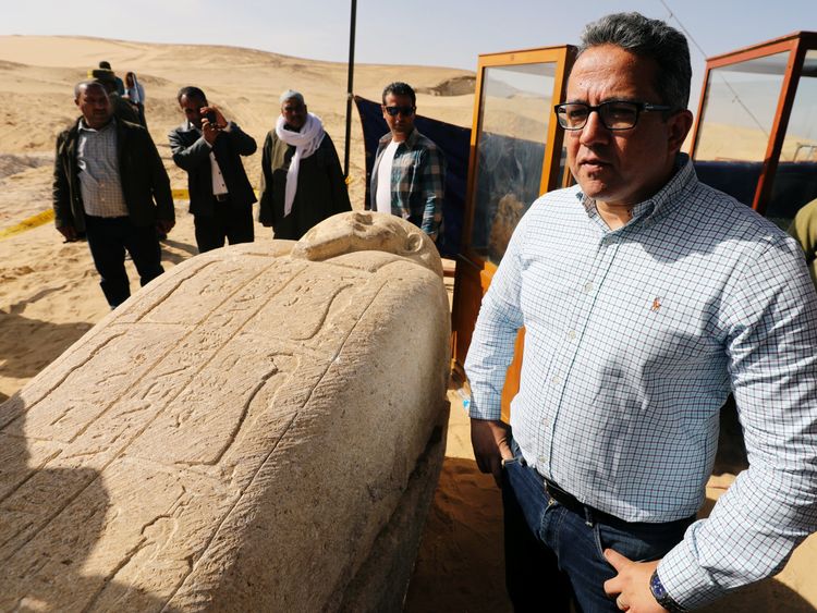Minister of Antiquities Khaled El-Enany stands near a stone sarcophagi