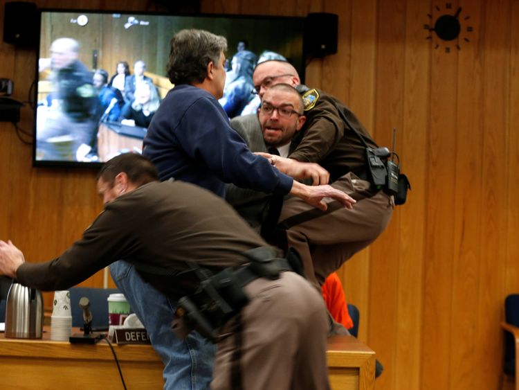 Randall Margraves (2ndL) lunges at Larry Nassar, (wearing orange) 