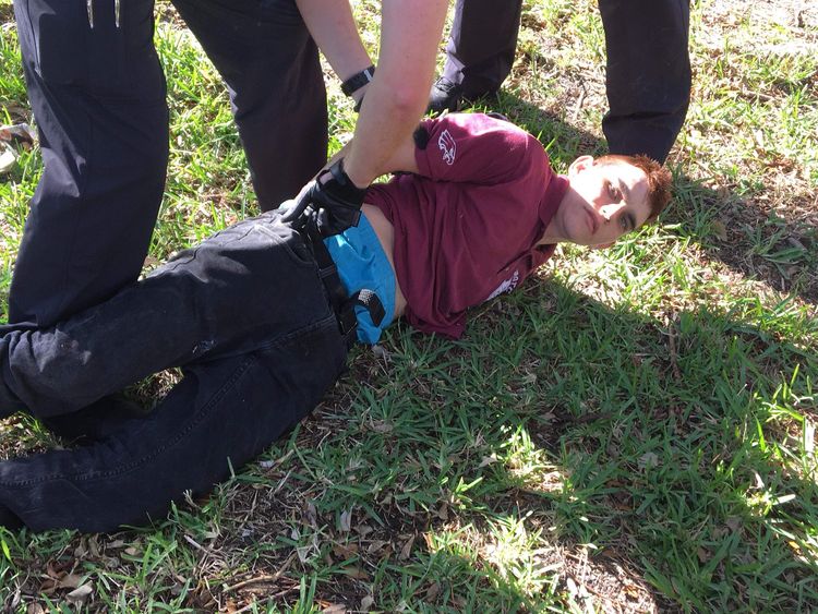Police detain Nikolas Cruz at the scene of the Parkland school shooting
