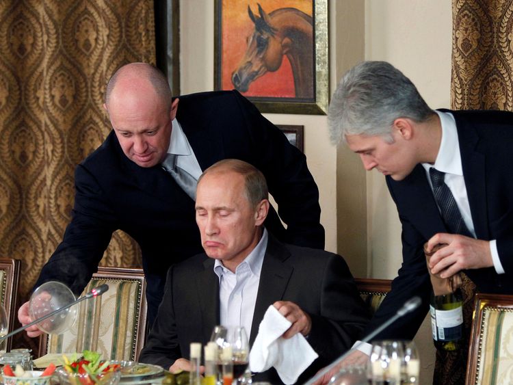 Evgeny Prigozhin (L) assists Vladimir Putin during a dinner in 2011