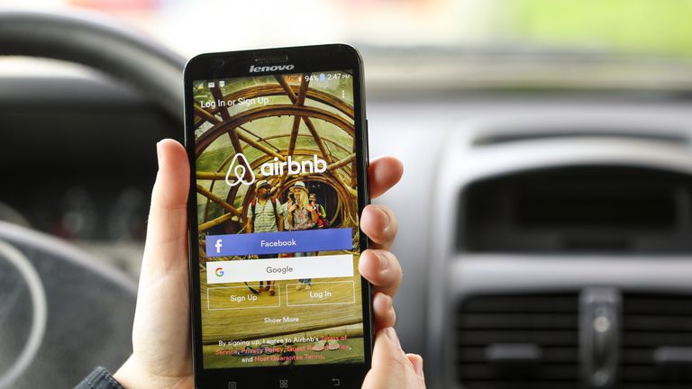 Close-up of an unrecognizable woman using the Airbnb App on her Lenovo A916 Android smartphone in a car. Login screen with Facebook and Google sign up options. Airbnb is a service for people to list, find, and rent lodging. It currently has over 1,500,000 listings in 34,000 cities and 190 countries.