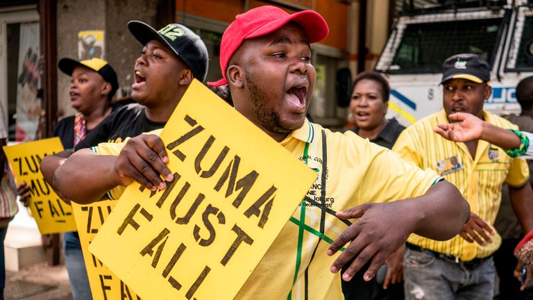 Supporters of the ANC Deputy President Cyril Ramaphosa hold placards and chant slogans outside the ANC party headquarter in Johannesburg