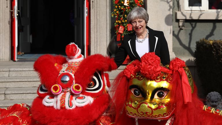 Prime Minister Theresa May stands with Dragons outside the British Embassy in Beijing on February 1, 2018 in Beijing, China