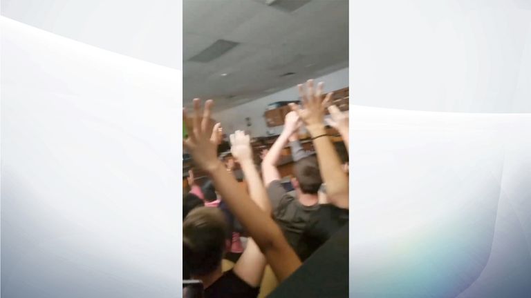 Students raise their hands as armed police enter a classroom. Pic: Alexander Ball