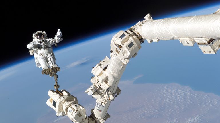 IN SPACE - AUGUST 3: In this NASA handout, mission specialist, Astronaut Stephen K. Robinson, is anchored to a foot restraint on the International Space Station&#39;s Canadarm2 robotic arm, during his space walk to repair the underside of the space shutttle Discovery August 3, 2005. Space shuttle Discovery is scheduled to return to Earth August 8. (Photo by NASA via Getty Images)

