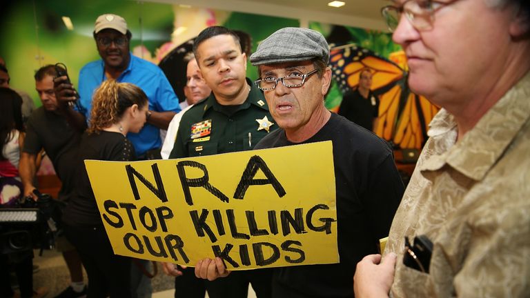 A protester holds a sign that reads &#39;NRA Stop Killing Our Kids&#39; following the Florida massacre