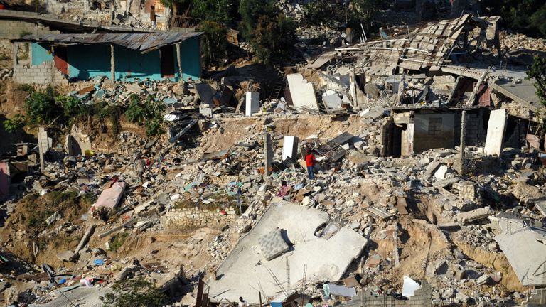 A man searches through the rubble in Port-au-Prince on January 18, 2010 after the country was rocked by a massive 7.0-magnitude quake