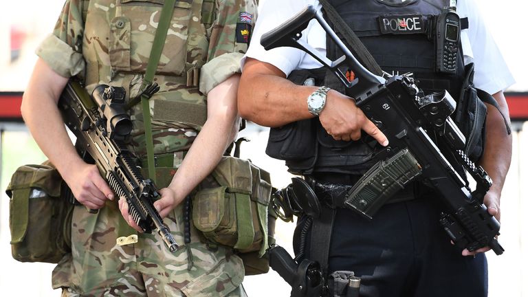 A British Army soldier patrols with an armed police officer near the Houses of Parliament in central London on May 24, 2017