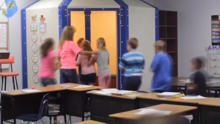 A teacher urges children to rush into a bulletproof shelter in their classroom. Pic: ABC/Koco