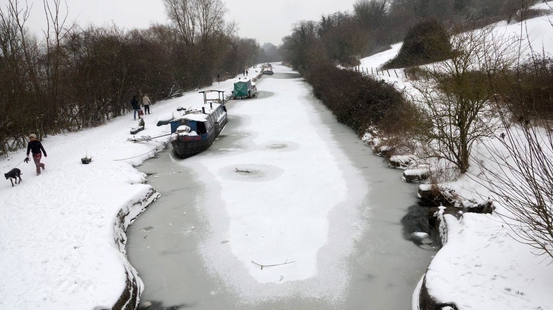 People walk along the snow-covered tow path on the frozen Kennet and Avon Canal on March 2, 2018 in Bath, England.