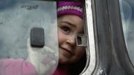 A Syrian girl opens the bus window after being evacuated from Eastern Ghouta on Sunday