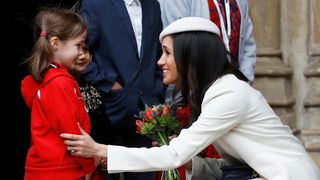 Britain's Prince Harry's fiancee Meghan Markle receives a bouquet of flowers after attending the Commonwealth Service