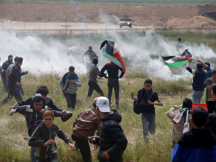 Palestinians run from tear gas fired by Israeli troops