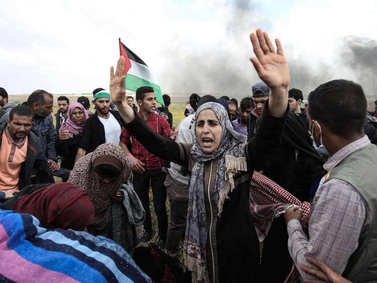 Palestinian protesters wave their national flag and gesture during a demonstration commemorating Land Day near the border with Israel, east of Khan Yunis, in the southern Gaza Strip on March 30, 2018