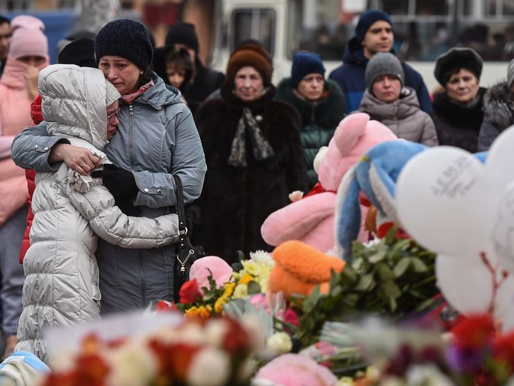 People grieve at a makeshift memorial in Kemerovo