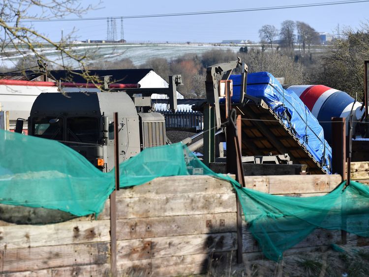 A vehicle covered in a tarpaulin is loaded onto an army vehicle in Durrington, near Salisbury