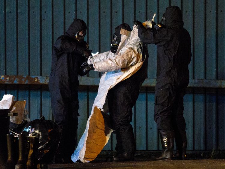 Police officers remove their protective suits on an industrial site as they continue investigations into the poisoning of Sergei Skripal 