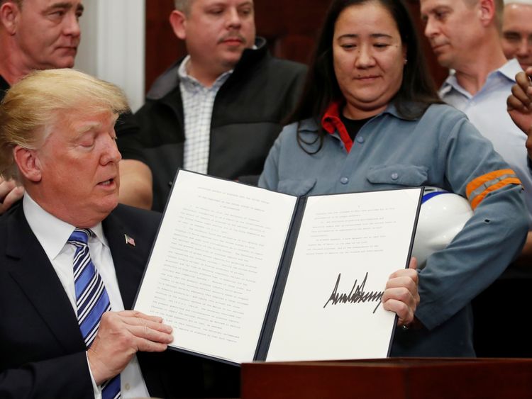 Donald Trump signs a presidential proclamation placing tariffs on aluminium and steel imports