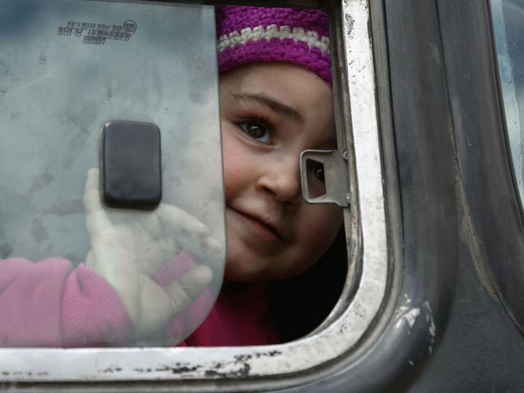 A Syrian girl opens the bus window after being evacuated from Eastern Ghouta on Sunday