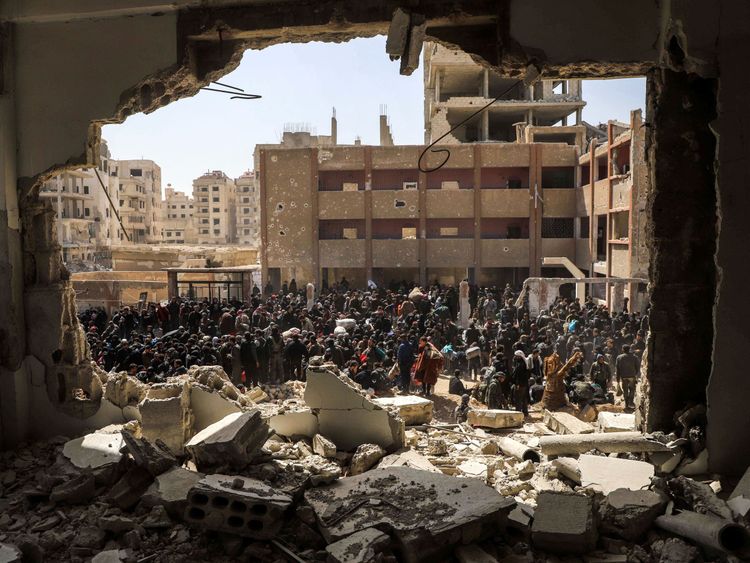 Syrian civilians gather for their evacuation from the town of Arbin in Eastern Ghouta on Sunday