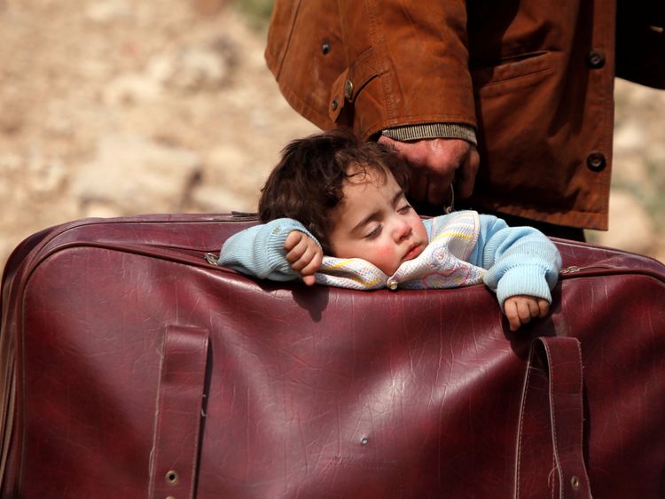 A child sleeps in a bag in the village of Beit Sawa, eastern Ghouta, Syria 