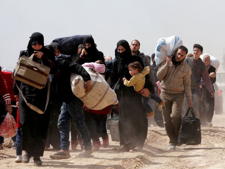 People walk with their belongings as they flee the rebel-held town of Hammouriyeh, eastern Ghouta