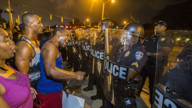 Protesters face off with Baton Rouge police in riot gear across the street from the police department on July 8, 2016 in Baton Rouge, Louisiana