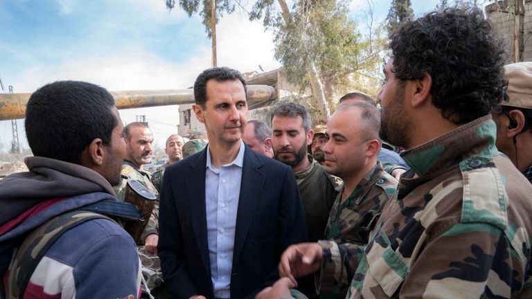 Syrian President Bashar al-Assad walks with Syrian army soldiers in eastern Ghouta