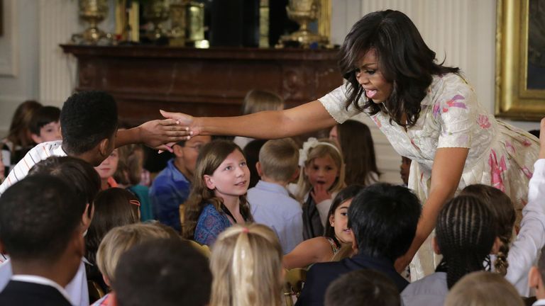 U.S. first lady Michelle Obama gives hugs and high-fives to children for Take Our Daughters and Sons to Work Day in the East Room of the White House April 20, 2016 in Washington, DC