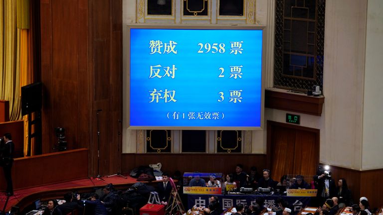 The results of the vote on a constitutional amendment lifting presidential term limits is seen on a giant screen
