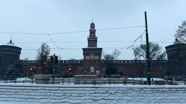 A snow-covered sidewalk in front of Sforzesco Castle in Milan 
