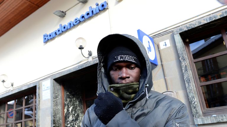 A migrant stands outside Bardonecchia train station in Italy