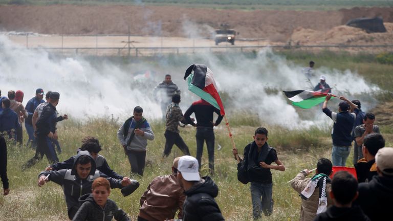 Palestinians run from tear gas fired by Israeli troops